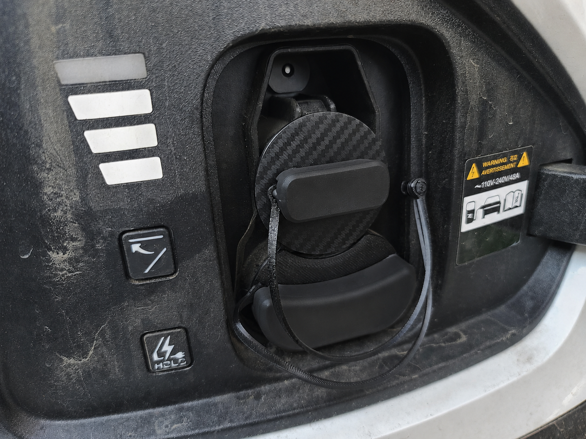 Electric vehicle charge port dust and moisture cover with low profile and swivel handle