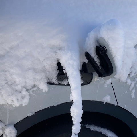 VW ID.4 buiten opladen met gemonteerde sneeuwkap voor de laadpoort